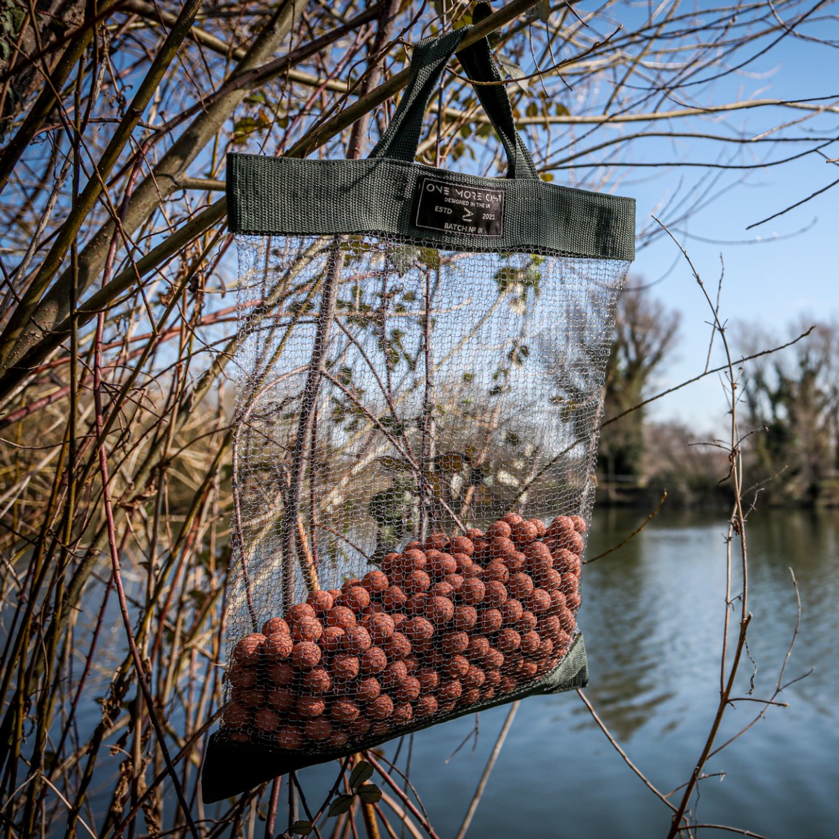 One More Cast rat bag hanging in tree, with boilies in bag